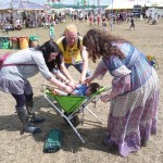 Glasto is tickling a baby in a barrow!