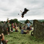 Young boy doing acrobatics off the stone circle