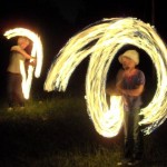 Two young lads juggle with fire at Stone Circle